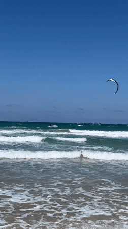 Kitesurfer performs tricks in moderate waves off Acre coast