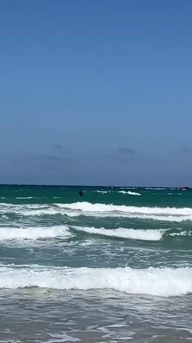 Kitesurfer performs tricks in moderate waves off Acre coast