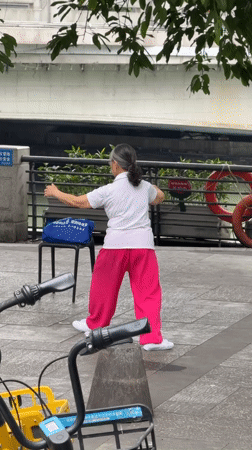 Elderly woman practices Tai Chi in Jinjiang District