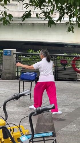 Elderly woman practices Tai Chi in Jinjiang District