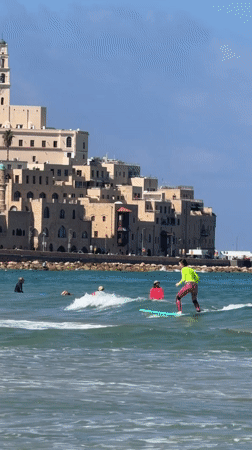 Sunny beach day: surfing, wading, and quiet shoreline moments