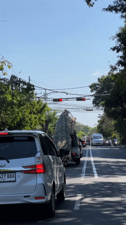 Morning traffic flows through Denpasar streets under clear skies