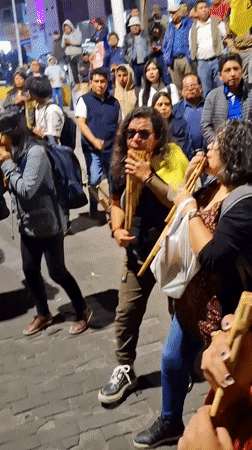 Street gathering features pan flute music, chanting in Arequipa