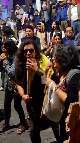 Street gathering features pan flute music, chanting in Arequipa