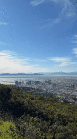 Aerial views over Cape Town reveal city, mountain, and crowd below