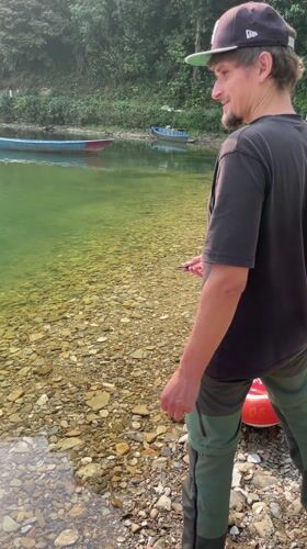 Person throws rocks into Phewa Lake during early morning hours