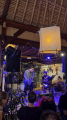 Saxophonist performs with band at distinctive thatched-roof venue
