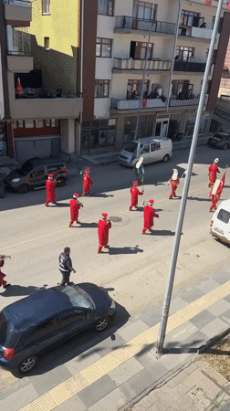 Red-robed procession marches through flag-lined streets in Gölbaşı
