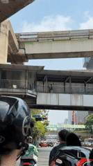 Motorcycle captures Bangkok's layered urban infrastructure at traffic light