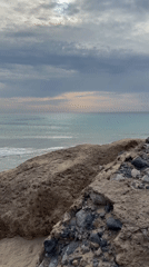 Calm turquoise coastline with rocky shore and mountain backdrop