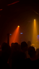 Moscow nightclub scene with dancing crowd under colored spotlights