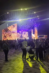 Nighttime outdoor concert with LED stage and branded QR display