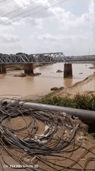 Metal bridge over muddy river observed in Barnawa, Nigeria