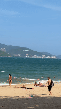 Morning at Nha Trang's Happy Beach: swimmers, wingsurfer, colorful huts