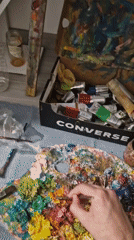 Artist paints sunflowers with oil paints using makeshift supplies