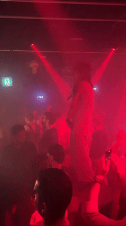 Live performance under red lights draws a crowd in Seoul