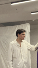 Two people wave and dance in dimly lit room
