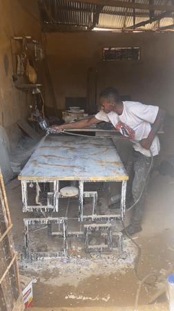 Nigerian artisans craft gold-veined countertop in outdoor workshop