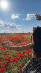 Woman poses in poppy field near Lozen, Bulgaria