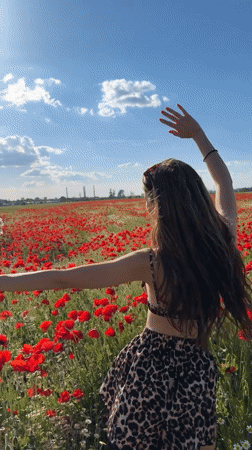 Woman poses in poppy field near Lozen, Bulgaria
