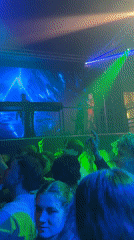 DJ performs at crowded Prague venue with colorful lighting