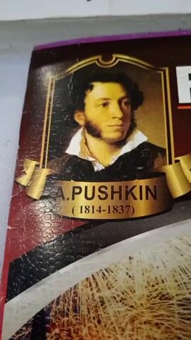 The video starts with a close-up of a book cover depicting A. Pushkin. The camera zooms out to reveal another book titled "BIOLOGIYA MILLIY SERTIFIKAT," which is a biology national certificate test book. The scene then shifts to an empty classroom, with tables and chairs covered in plastic.