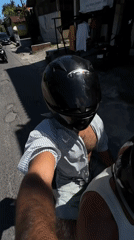 Scooter passenger films selfie video in Kediri, Indonesia