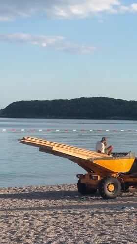 Two men operate yellow vehicle on Montenegro beach