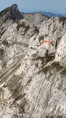 Paragliders fly Swiss mountain slopes near a radar-topped peak