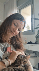Woman pets tabby cat in morning moment in Ramat Gan