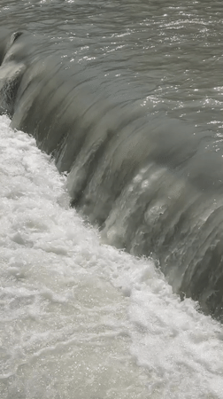 Turbulent water churning over a concrete weir in Bishkek