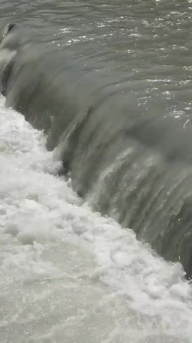 Turbulent water churning over a concrete weir in Bishkek