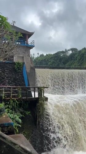 Flooded dam and truss bridge along a Klungkung river