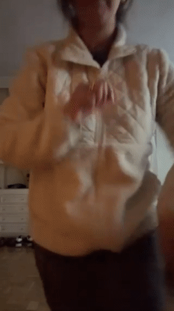 Woman dances to music in Madrid home during afternoon