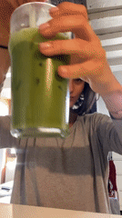Woman enjoys green drink on couch in Paris