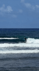 Surfer rides wave in early morning waters near General Luna