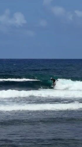 Surfer rides wave in early morning waters near General Luna