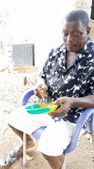Man enjoys outdoor meal in purple chair, Akwanga Nigeria