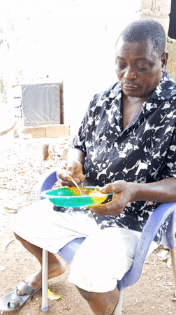 Man enjoys outdoor meal in purple chair, Akwanga Nigeria