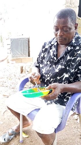 Man enjoys outdoor meal in purple chair, Akwanga Nigeria