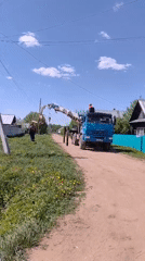 Utility truck with crane operates on rural road in Markovo