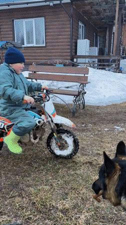 Child rides dirt bike in snowy Russian yard