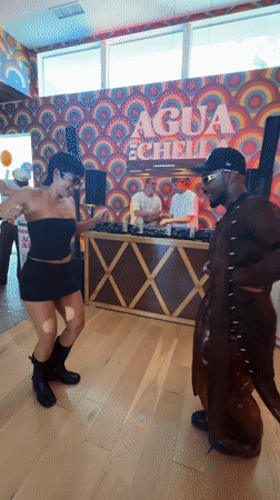 Indoor party with DJs, dancing, and service dog documented in Indio