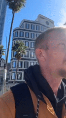 Man photographed near downtown LA freeway, skyscrapers visible
