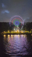 Colorful Ferris wheel operates at night in Cherepovets park