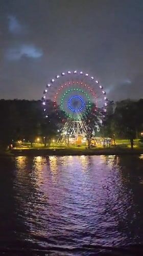 Colorful Ferris wheel operates at night in Cherepovets park
