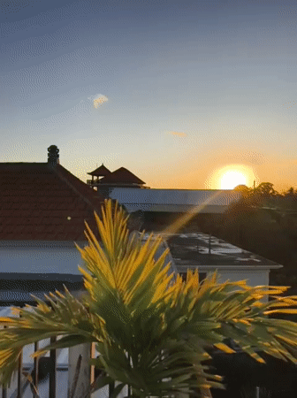 Sunset views captured over traditional rooftops in Kutuh, Indonesia