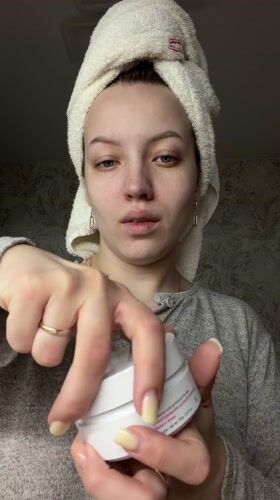 Woman applies eye patches during morning skincare routine in Russia