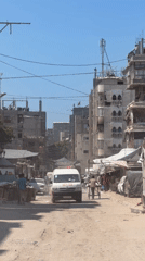 Ambulance and rubble-strewn alley in damaged Gaza streets