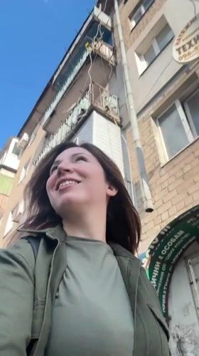 Woman in green walks, smiles in sunny Kryvyi Rih